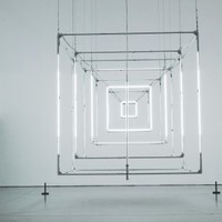 Intriguing geometric light installation in a minimal gallery setting.